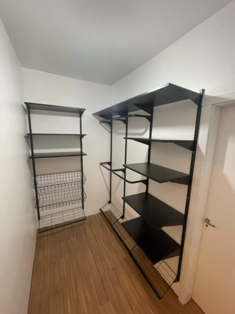 A foto mostra um sistema de closet modular com araras e prateleiras em MDF na cor preta, com pagamento realizado no momento da entrega.