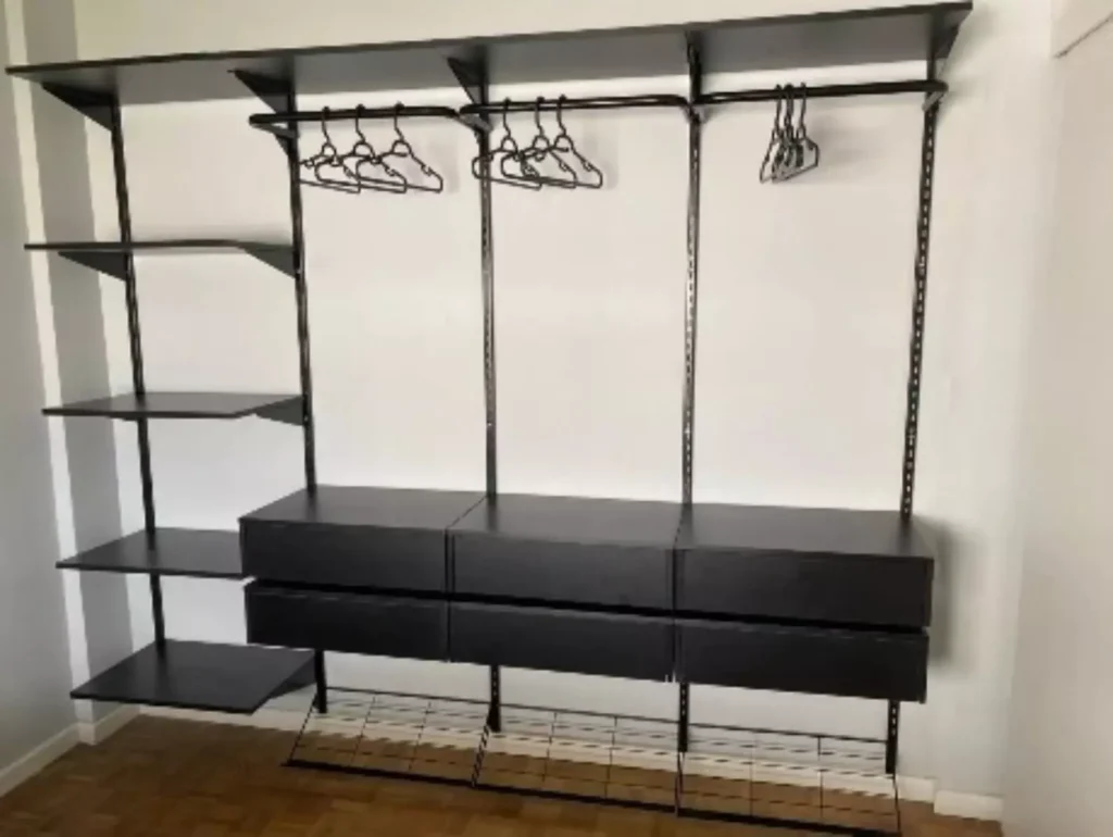 A imagem exibe um móvel aramado para organização de roupas com araras metálicas na cor preta, com pagamento na finalização do serviço.